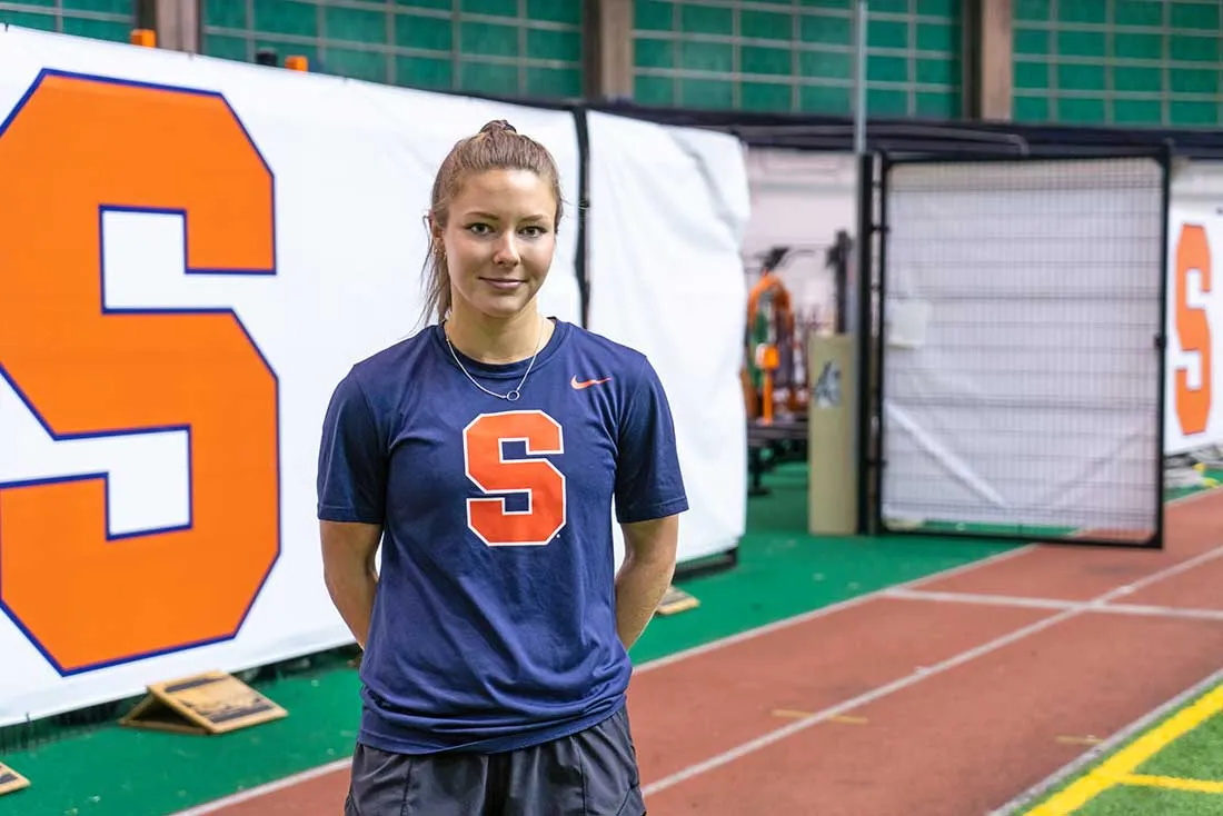 exercise science undergrad student stands in an indoor running field