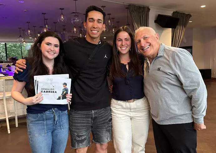 two female students standing with male yankee player and sports marketing expert