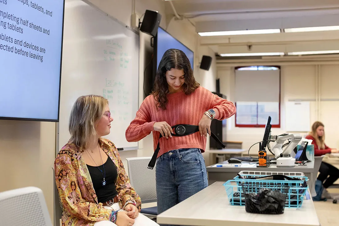 student shows electronic sensor that students wear during simulations