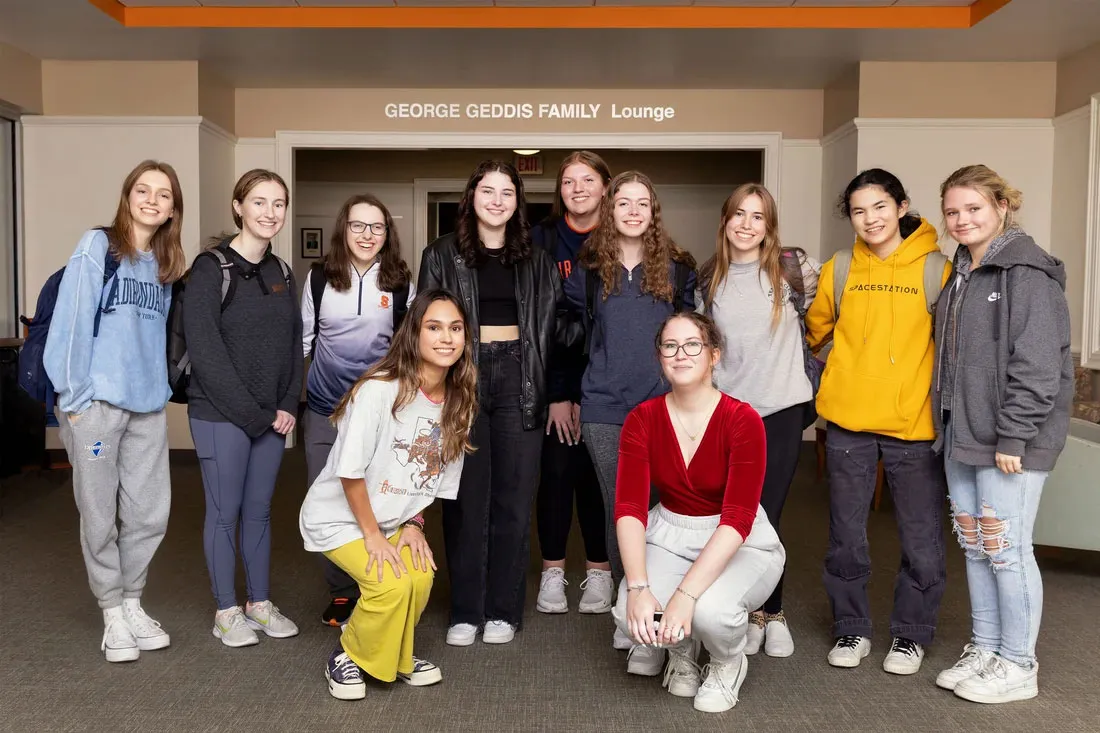 group of eleven female students standing in front of loune