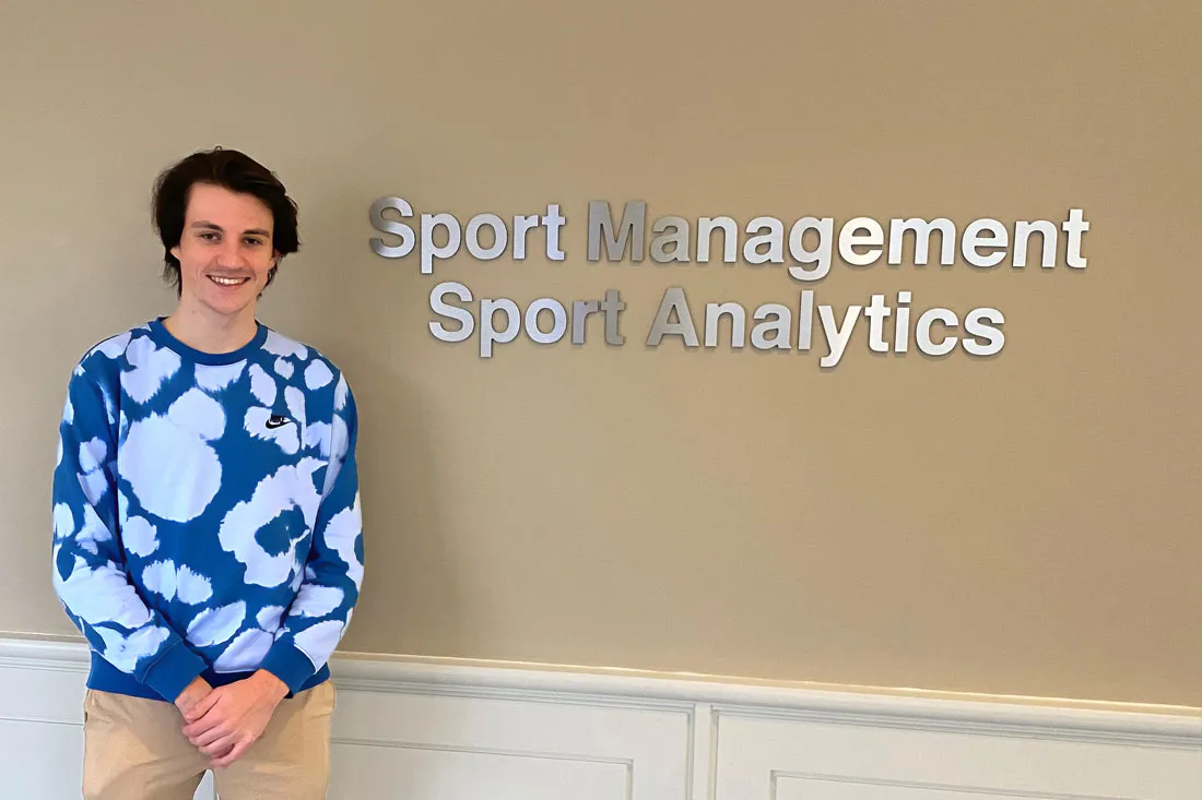 student standing in front of offices of sport management