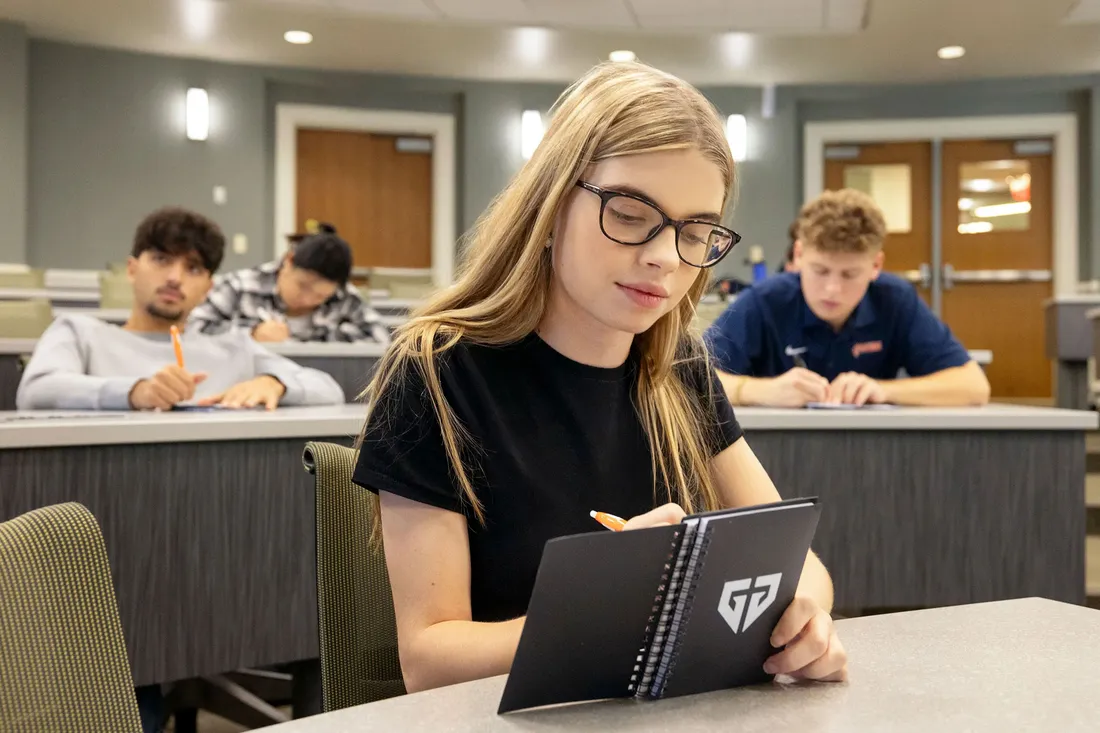 Emily Gates writing notes in class