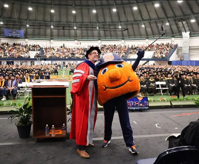 Dean Jordan takes a selfie with Otto the Orange at 2025 Convocation