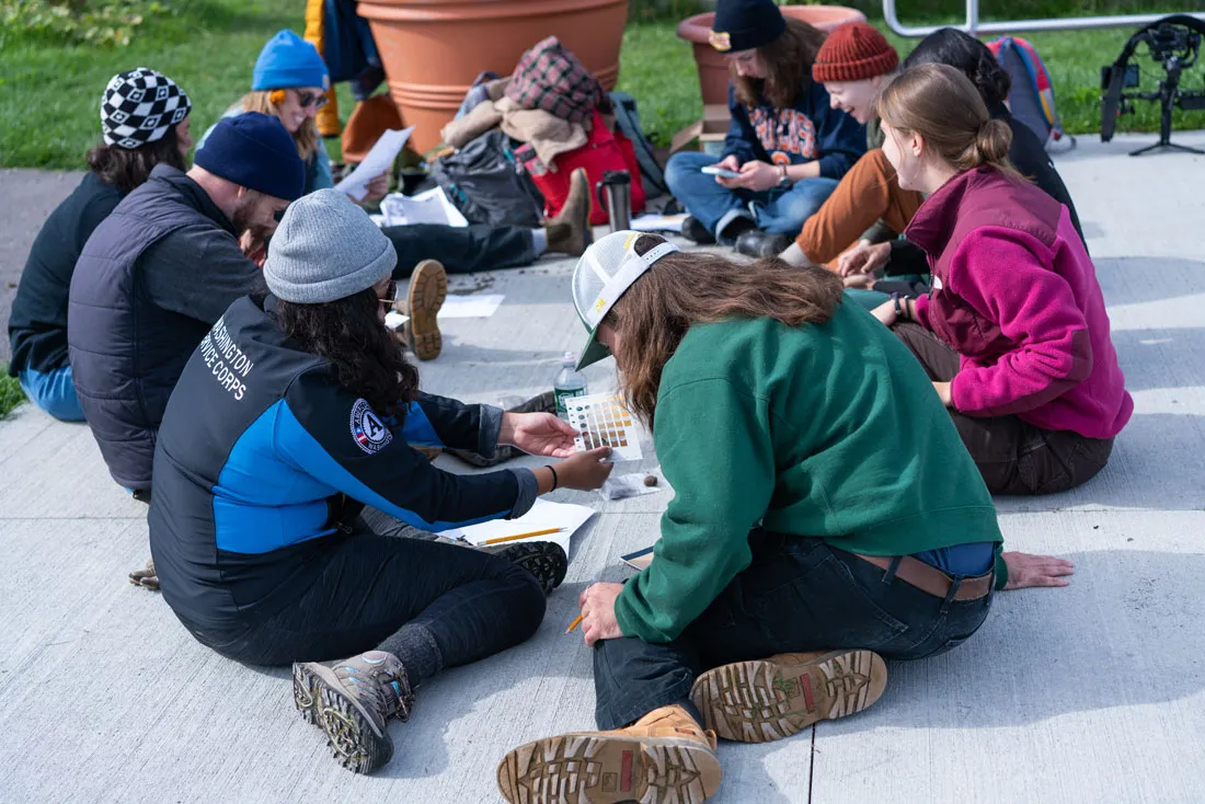 group of people sitting on sidewalk