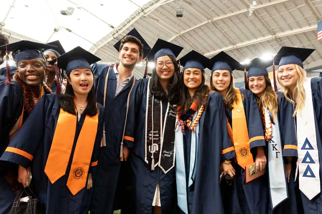 graduates in cap and gown standing together