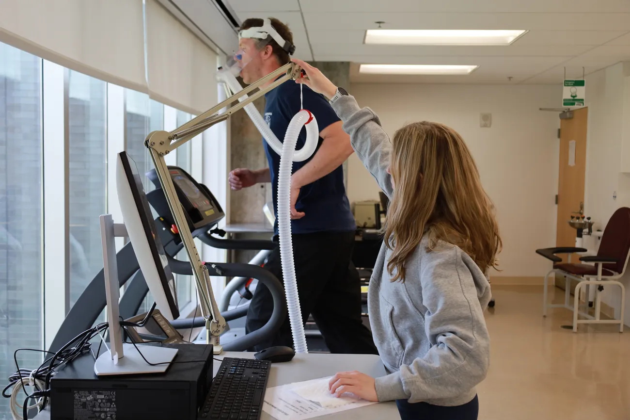 A student works with an athlete on a treadmill