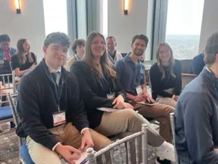 Four students sitting together at Symposium