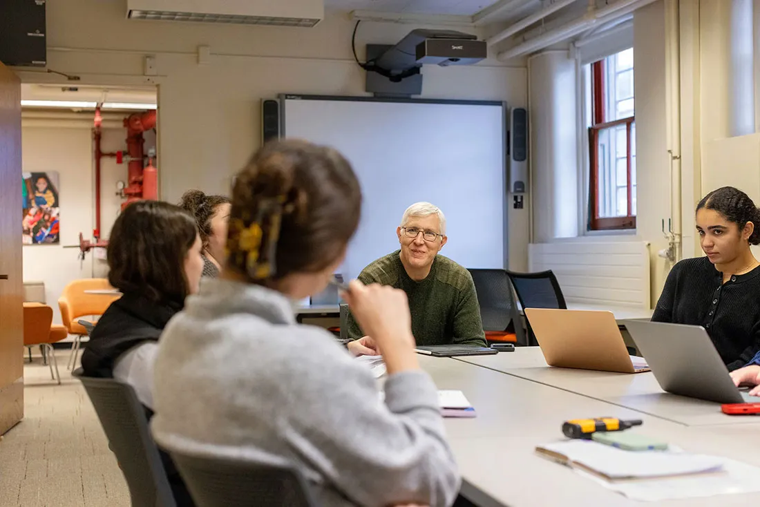 Professor meeting with students around a table