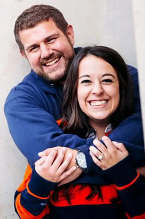 Husband standing behind wife with arms wrapped around her