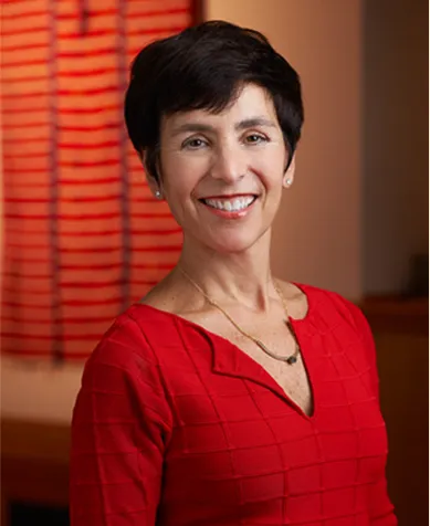 portrait of women with short dark hair wearing a red top, she is smiling