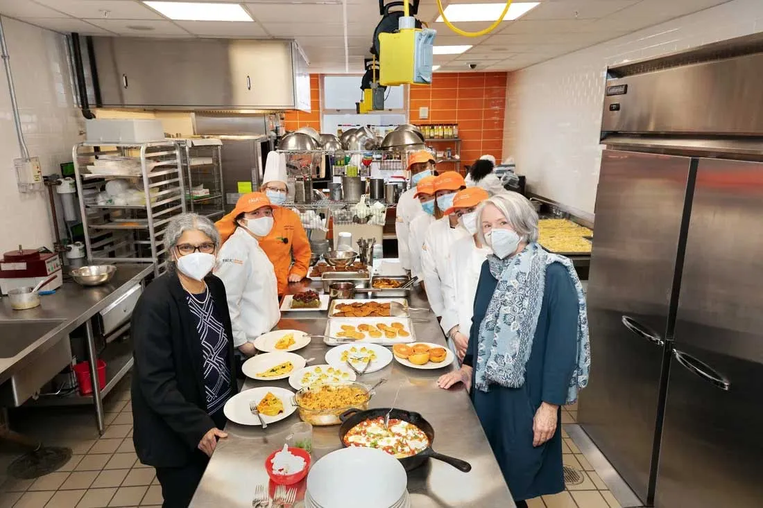 faculty standing around serving table in kitchen