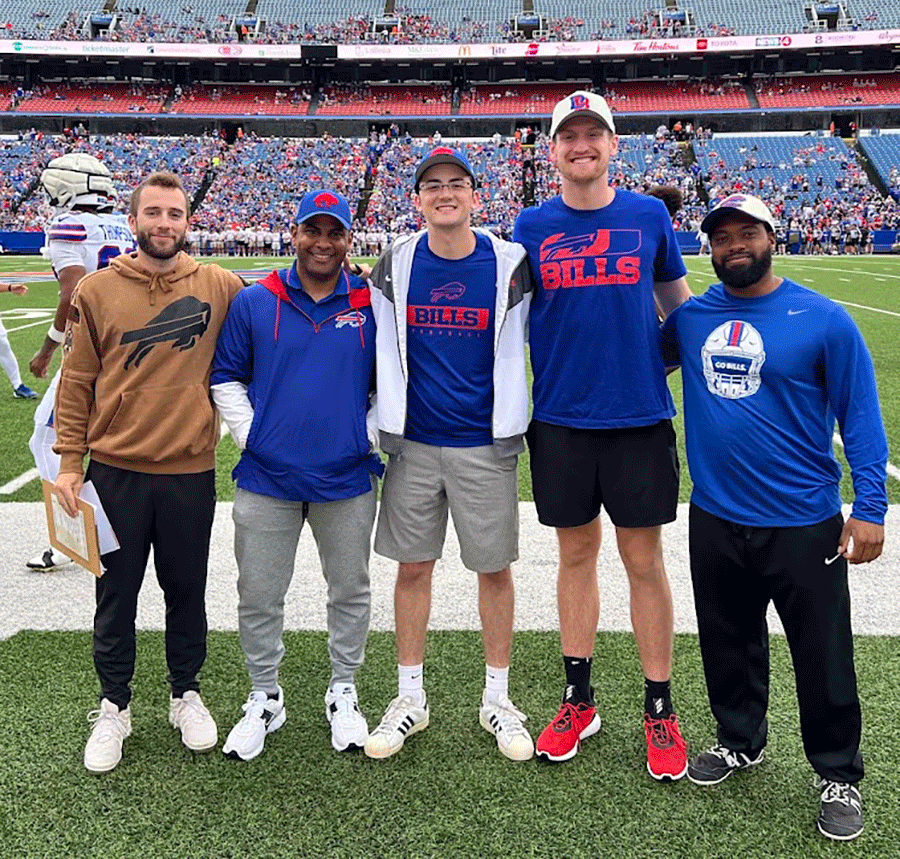 Five young men standing together on athletic field