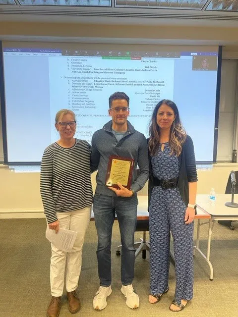 Professor receiving award from other professors