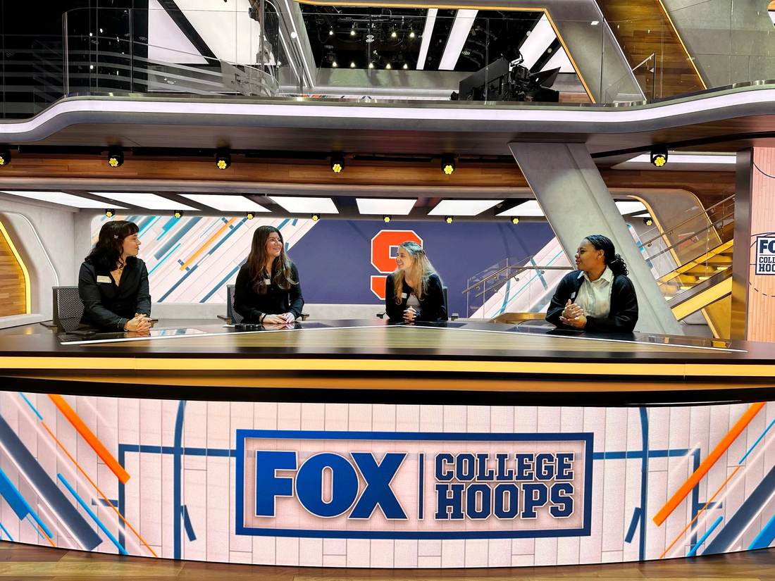 student sitting at Fox Sports news desk