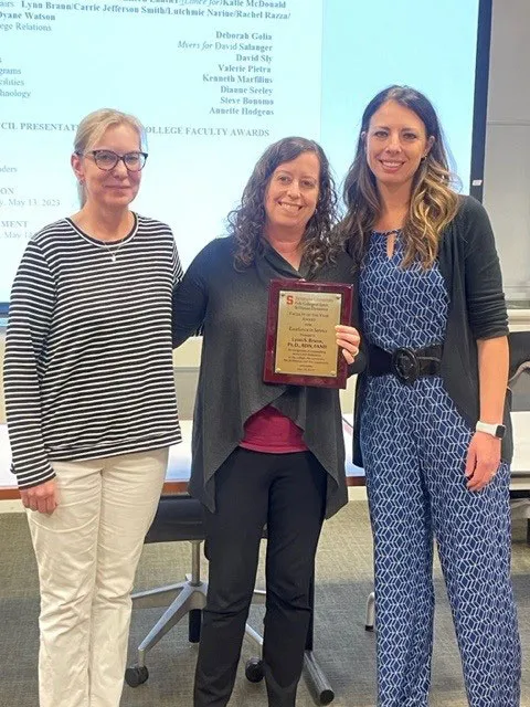 Professor receiving award from other professors