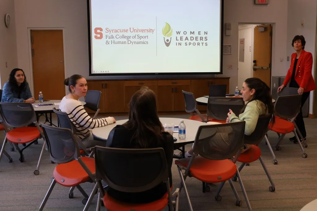 young women gathered at round tables discussing leadership