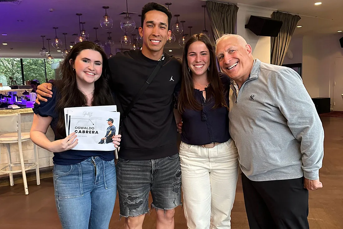 Brandon Steiner standing with three students