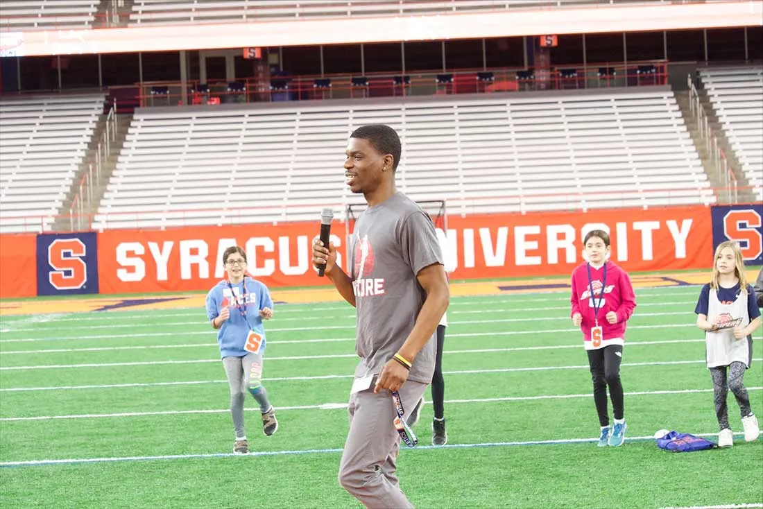 Tobi working on charity event on athletic field with youngsters