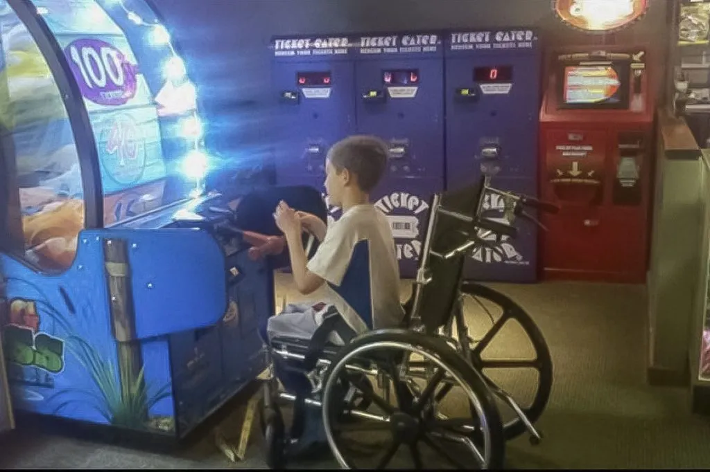 young boy in wheelchair at arcade