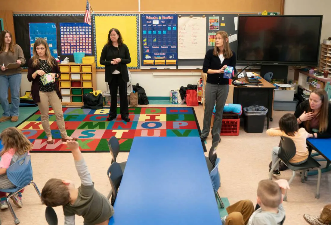 female professor talking with elementary students