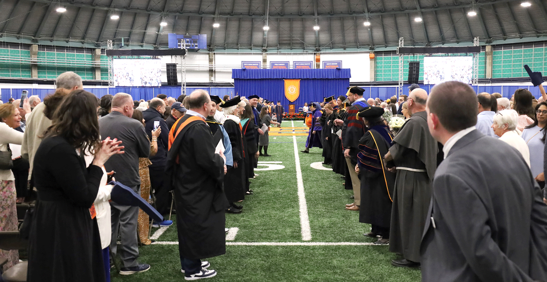 faculty members in line awaiting students to walk through