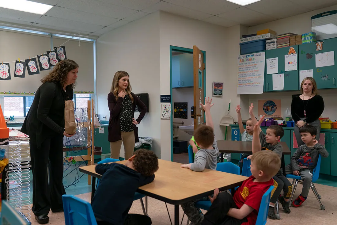 professors talking with young children in school