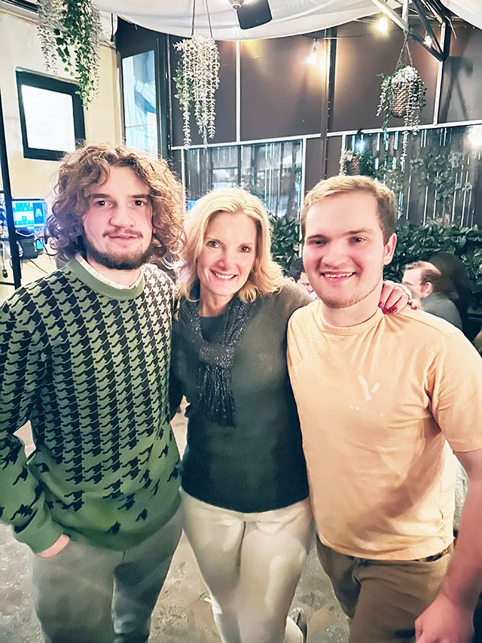 Mom with two grown sons standing together