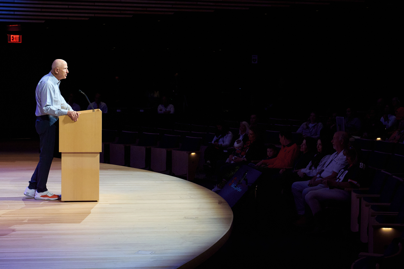 David B Falk standing at a podium speaking to a group of people
