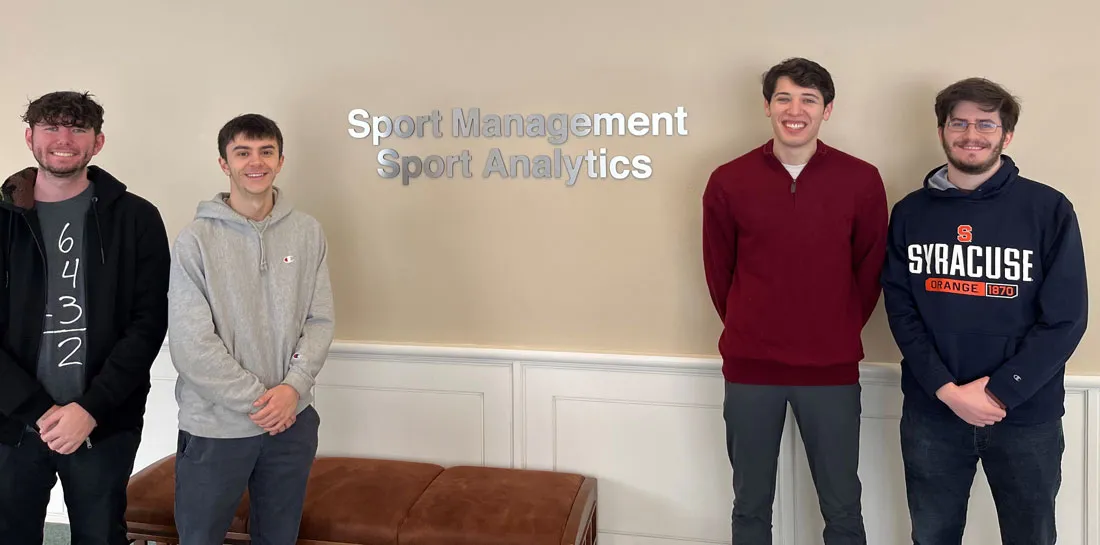 four analytics students standing in front of sport management office
