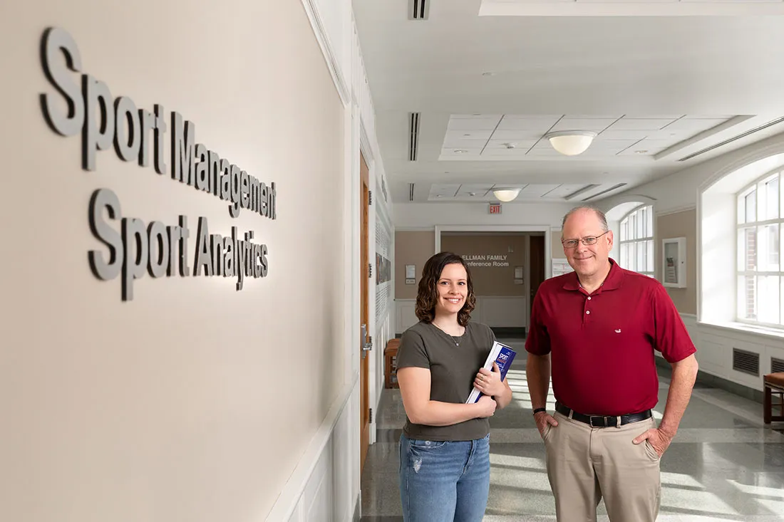 Professor and former student standing together outside the offices of Sport Manaement