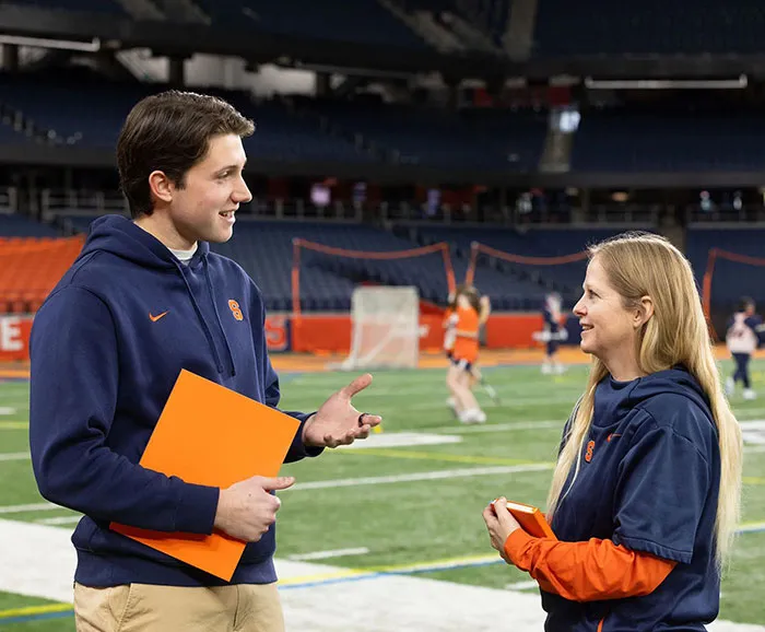 An analytics student talks with a coach