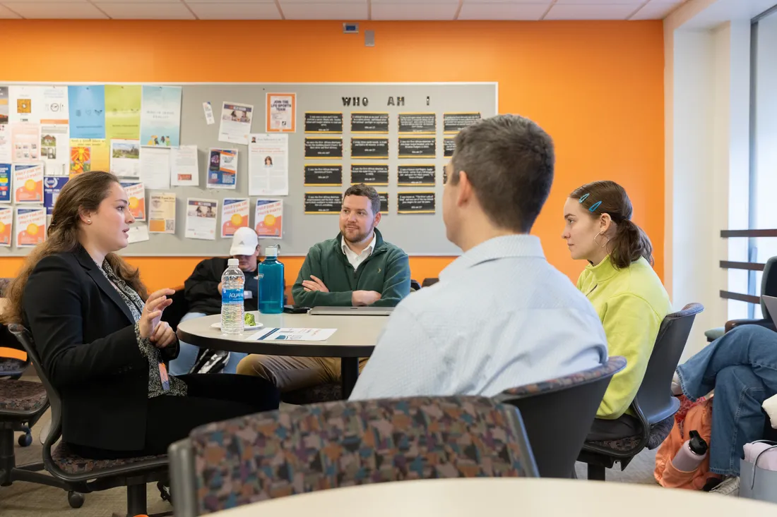 Alumni speak with students at a career fair at Falk College