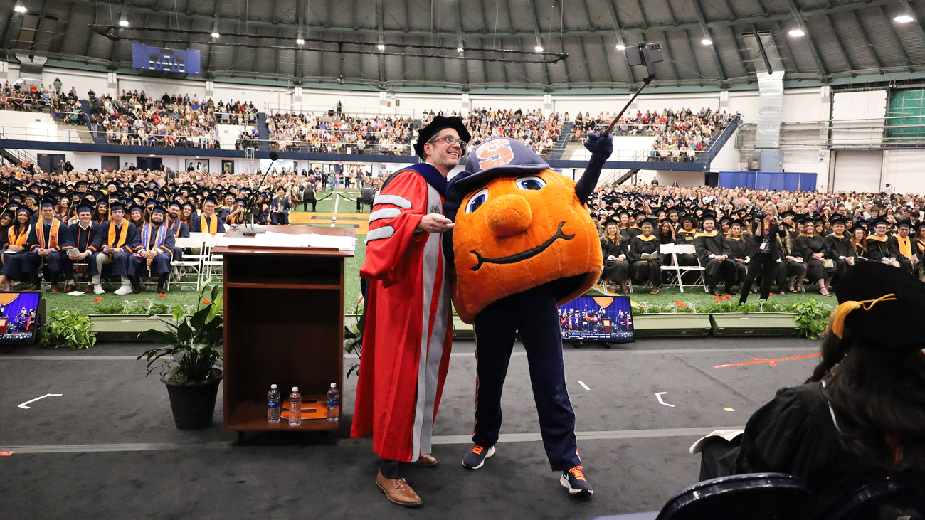 Dean Jordan and Otto standing on stage together at convocation