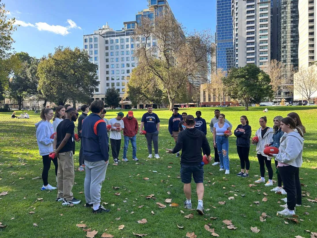 SU students outside on the grass learning to play rugby in Australia