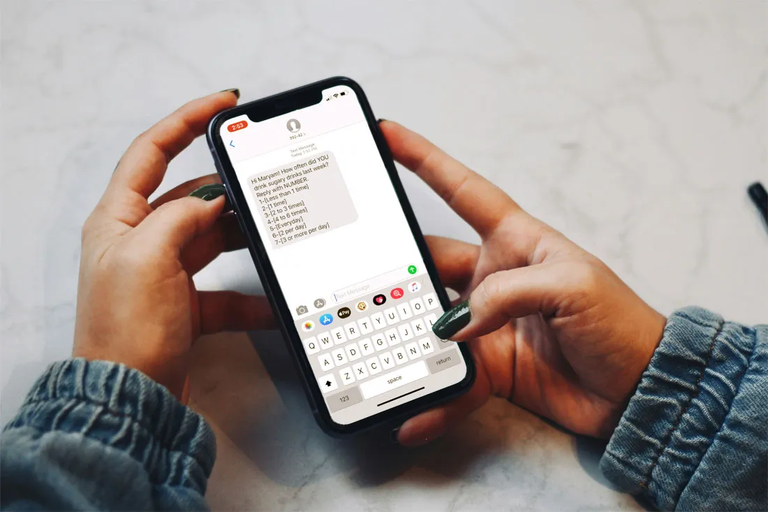 hands are holding a cell phone with a text message asking about sugar intake
