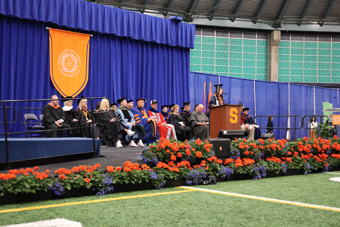student Rylie DiMaio introduces keynote speaker David B. Falk