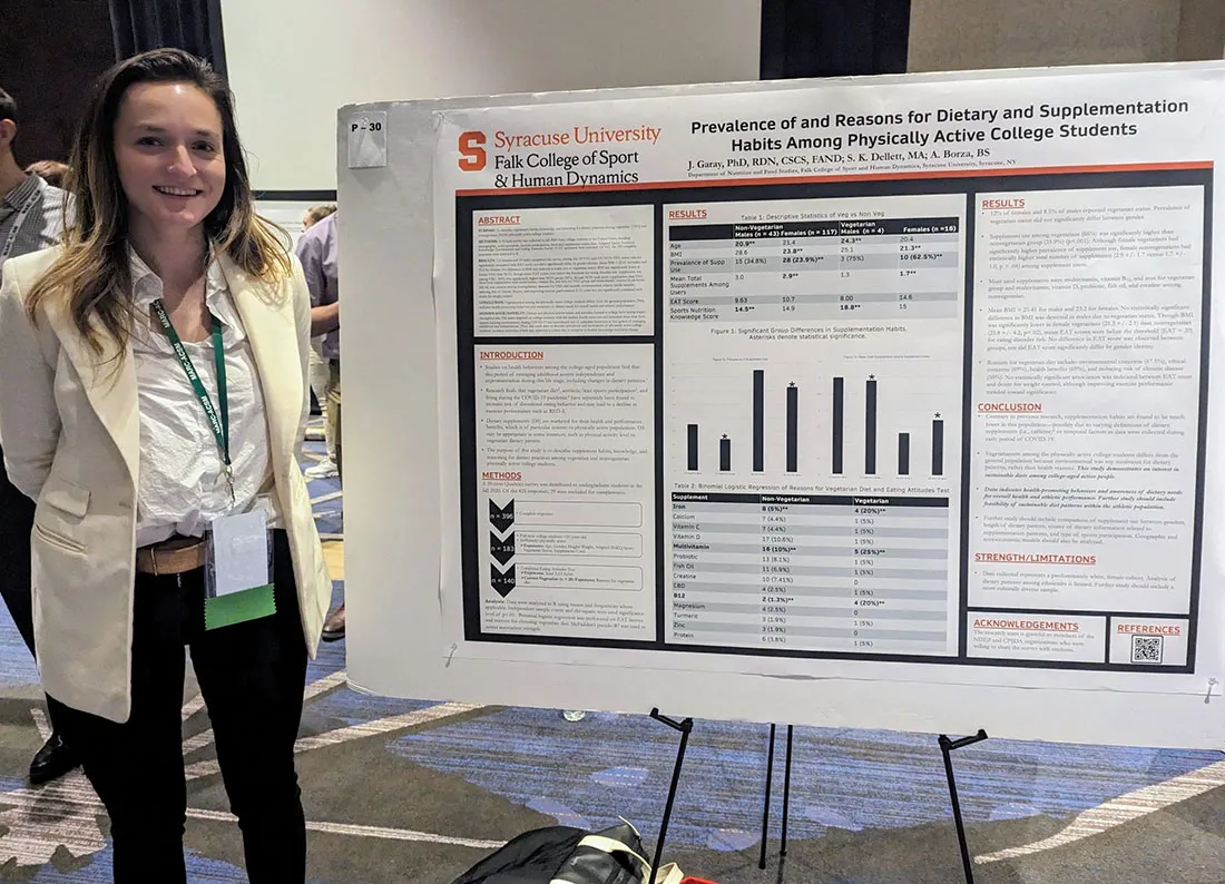 female student standing next to poster she created