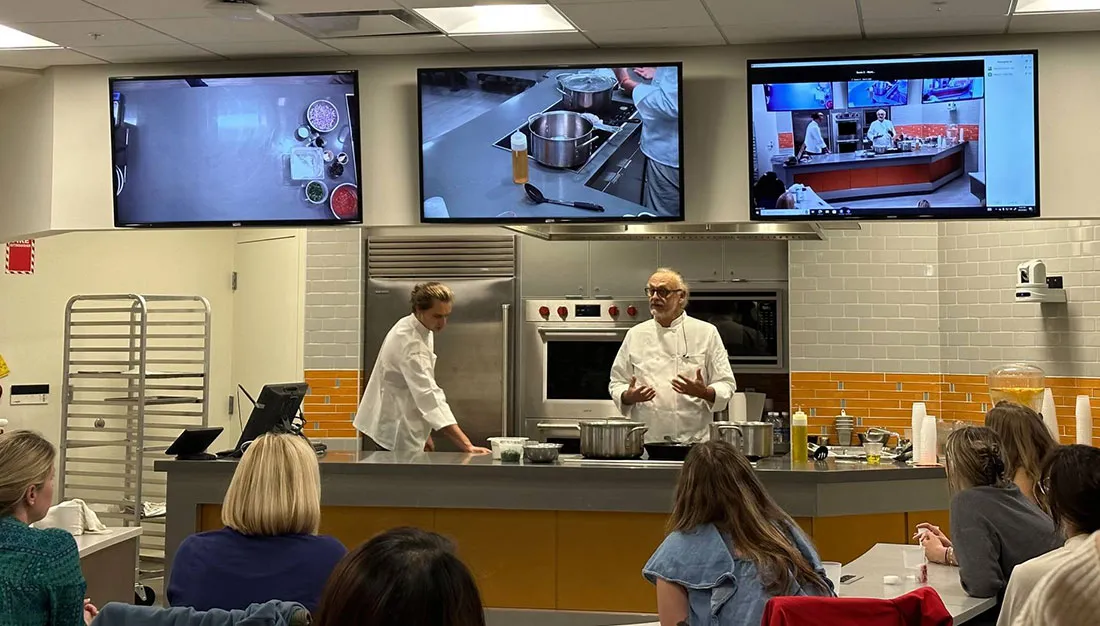 Chef standing behind teaching station speaking to a class