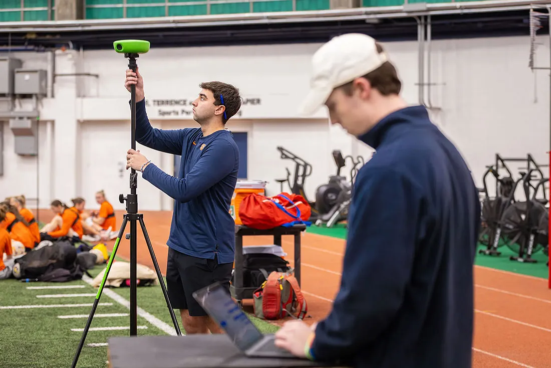 student setting up video equipment before womens soccer practice