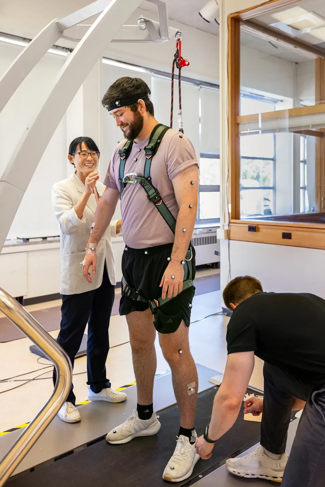 Professor monitoring male student on treadmill.