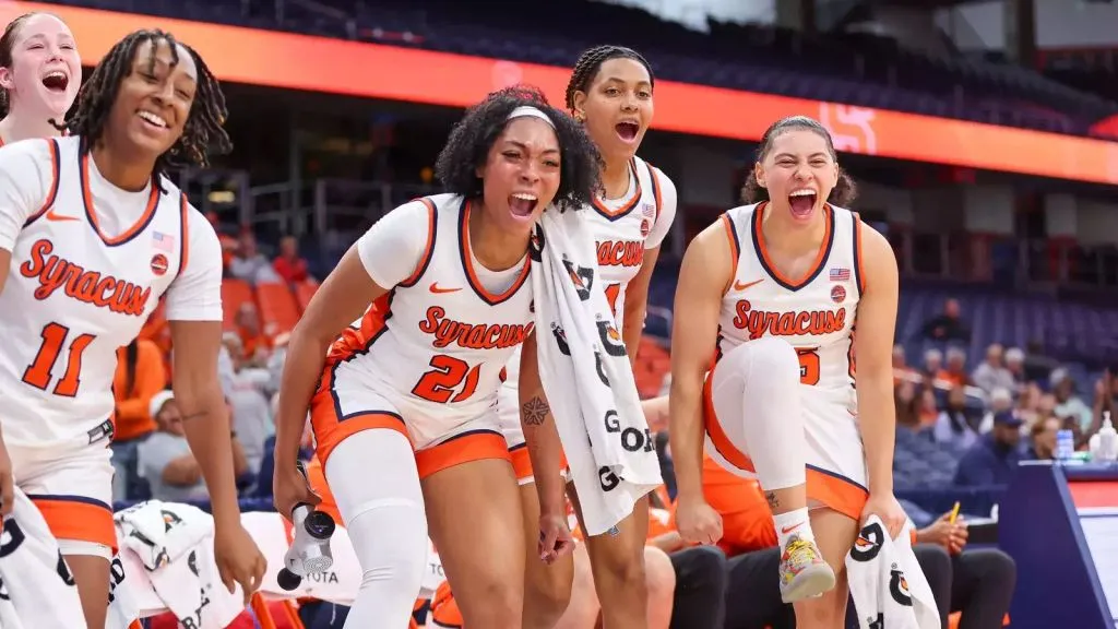 SU womens basketball players on the sidelines cheering on the team