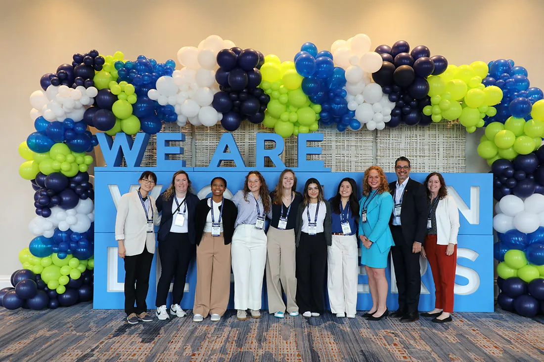 9 women standing together with one man at Women Leaders in Sports 2024 national convention