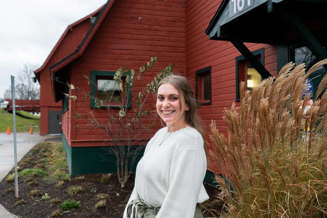 female in white shirt standing outside
