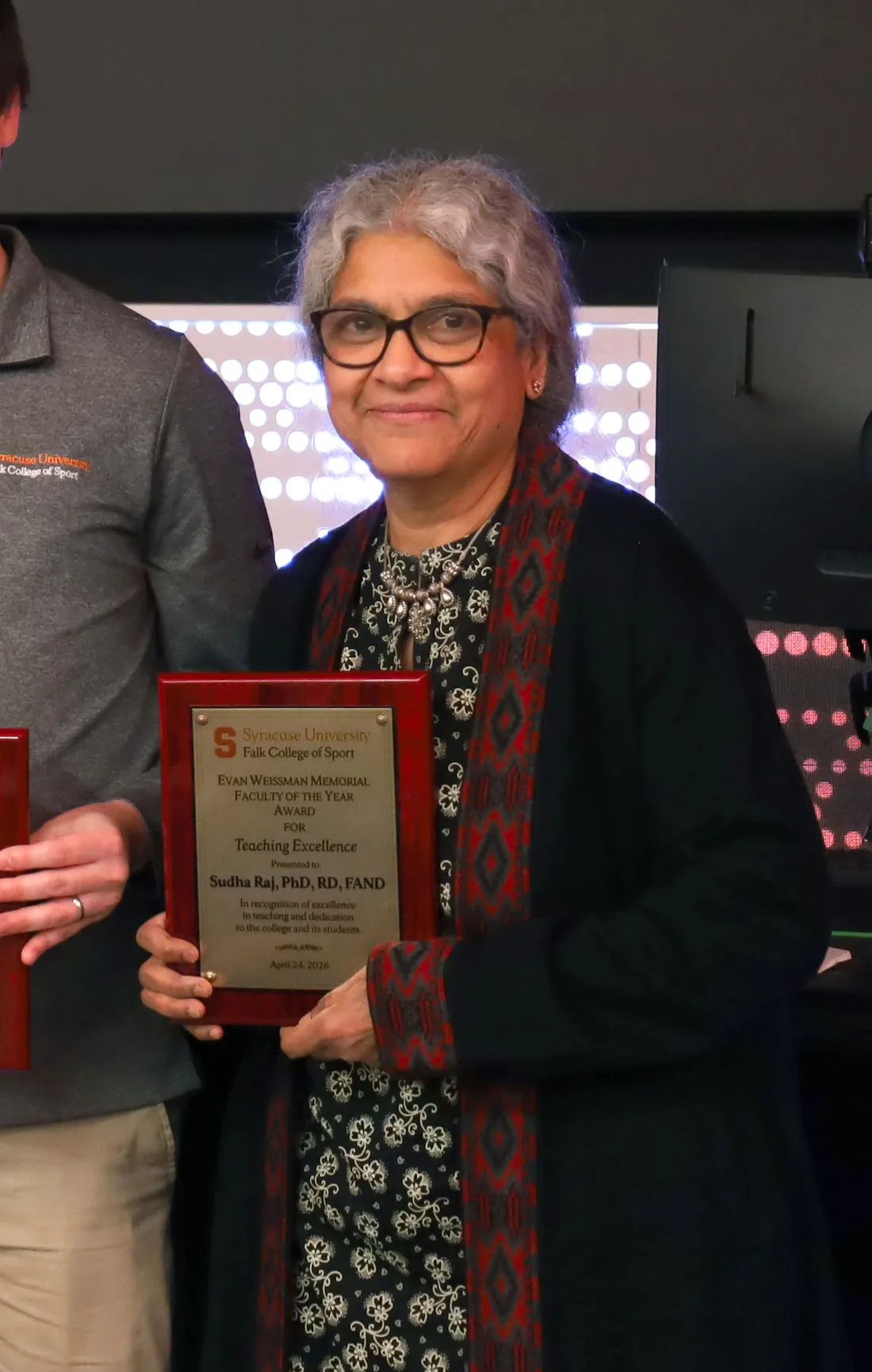 2026 Faculty of the Year award winners Harmon, Losak and Raj hold their awards.