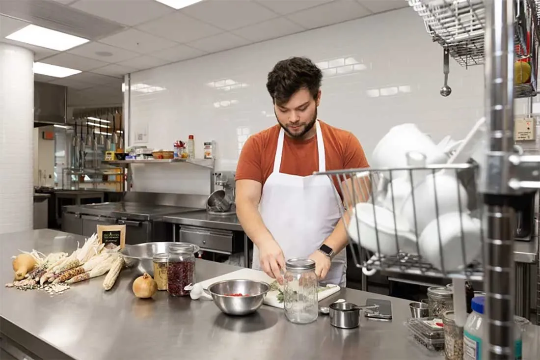 student prepares meal in kitchen