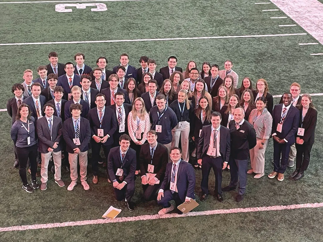 50 student volunteers standing on football field