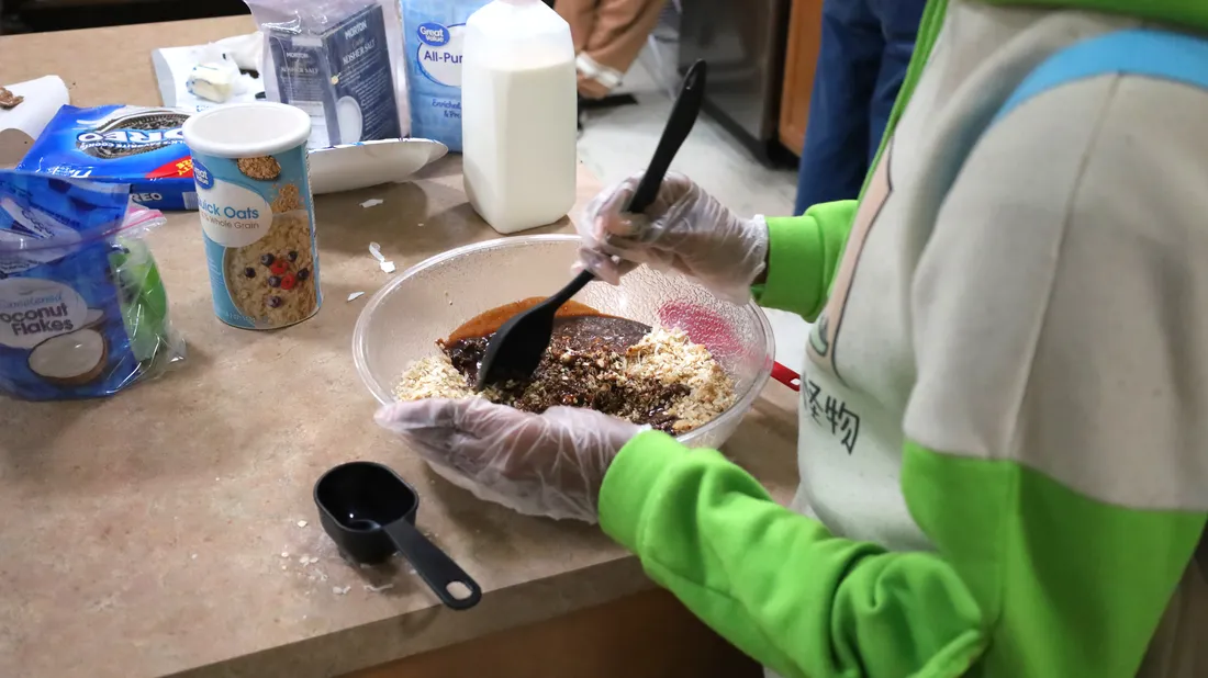 student stirring contents in a mixing bowl