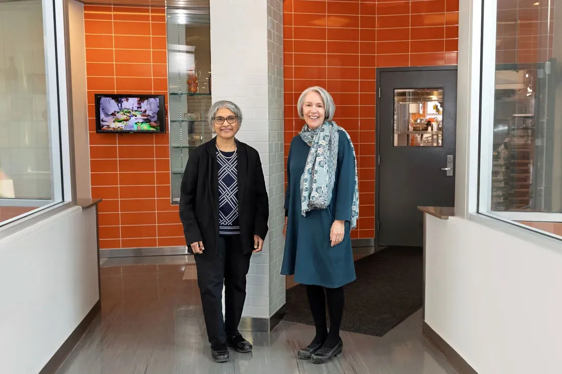 two female faculty members standing at entrance to the kitchens on Falk fith floor