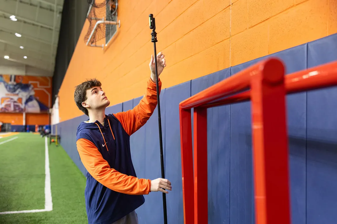 student sets up motion tracking sensor for men's soccer practice