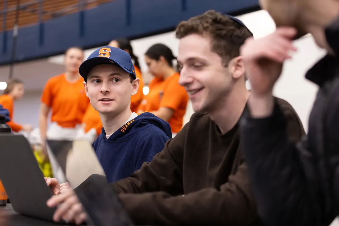 two students gathering stats for the softball team